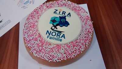 foto van een taart die lijkt op een beschuit met muisjes met daarop de naam ZiRA (Ziekenhuis Referentie Architectuur), een teddybeer met de tekst Kennis, een ingepakt cadeau met de tekst Ervaring en een fopspeen met op het lint Oplossingen